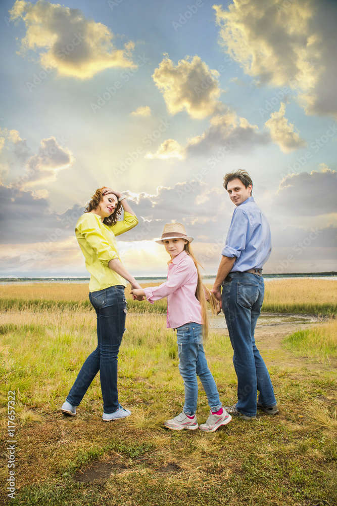 happy family mother, husband and daughter on a background of lake at rest happy family mother, husband and daughter on a background of lake at rest