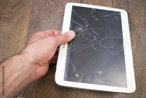 Hand holds tablet PC with broken touchscreen
