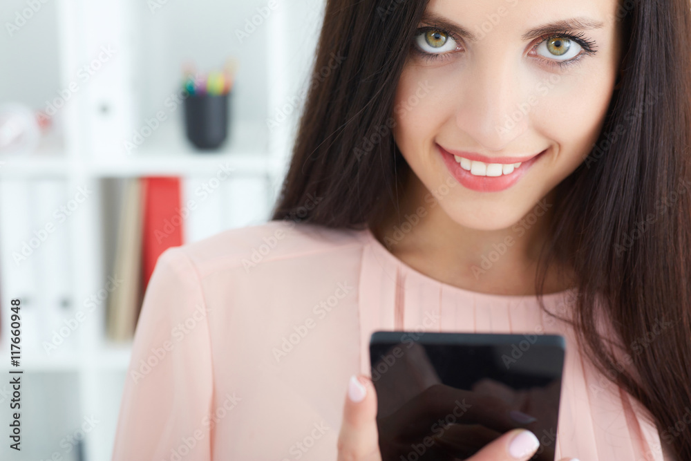 Girl texting on the smart phone in office with an unfocused background Girl texting on the smart phone in office with an unfocused background