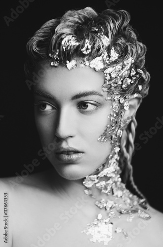 Portrait of beautiful fashion model with shiny foil on face and
