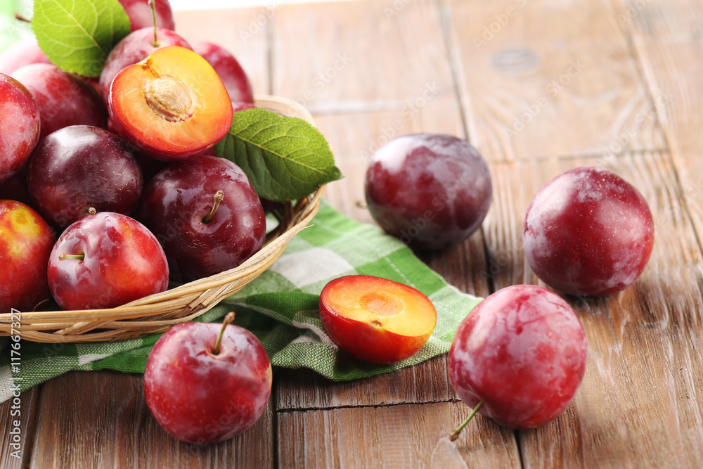 Fresh plums on a brown wooden table Fresh plums on a brown wooden table