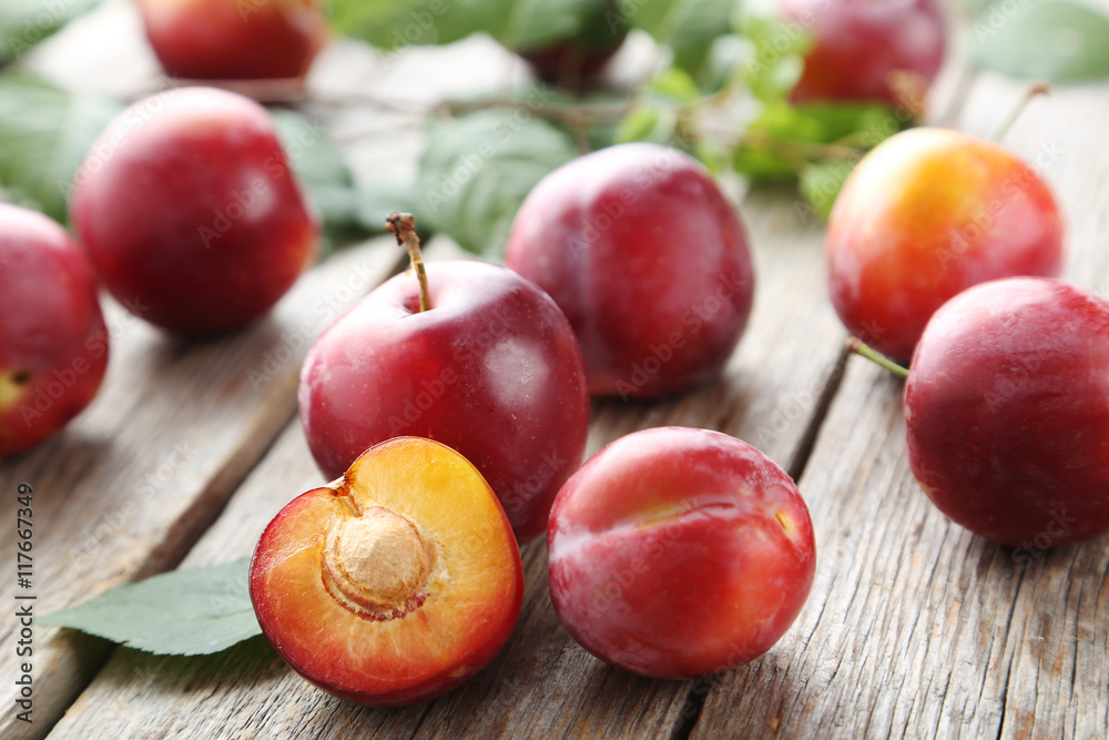 Fresh plums on a grey wooden table Fresh plums on a grey wooden table
