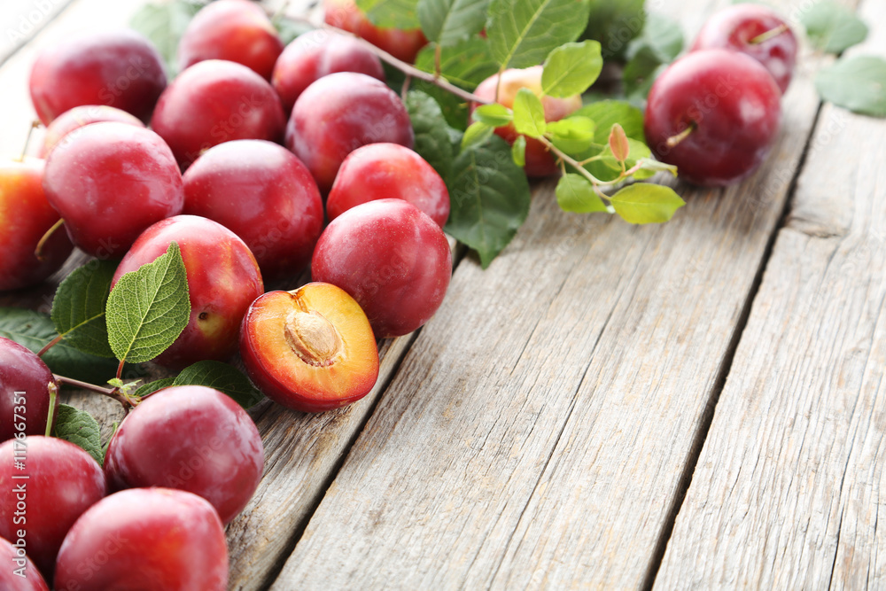 Fresh plums on a grey wooden table Fresh plums on a grey wooden table