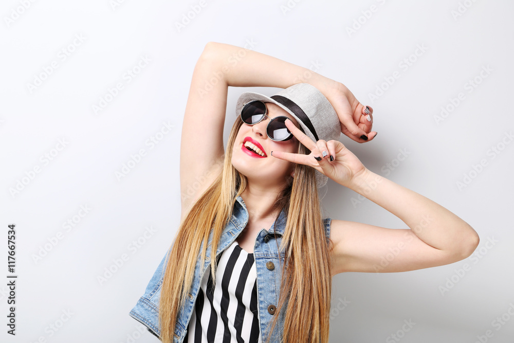 Fototapeta premium Portrait of a beautiful hipster girl on grey background