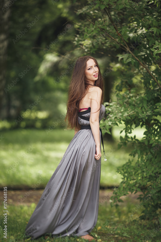 Beauty Romantic Girl Outdoors. Teenage Model with Casual Dress in park. Blowing Long Hair. Beauty Romantic Girl Outdoors. Teenage Model with Casual Dress in park. Blowing Long Hair.
