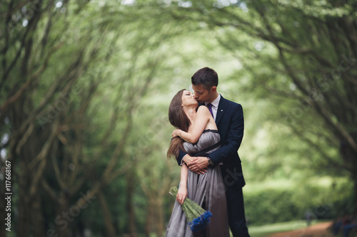 Fotografi Handsome young couple posing outdoors after ceremony