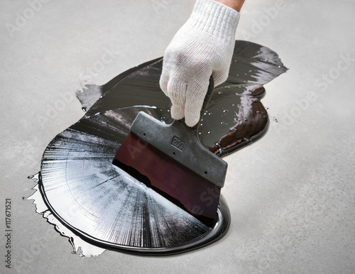 Work with a spatula on the bitumen on the surface photo