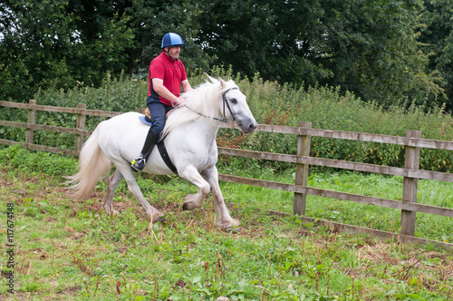 Rider enjoying a canter on a lovely grey horse