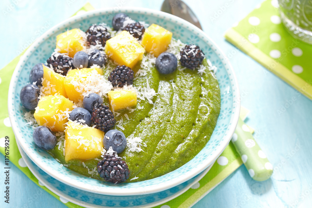 Breakfast green smoothie bowl topped with fruits Breakfast green smoothie bowl topped with fruits