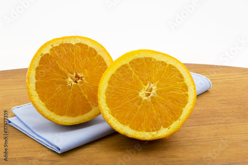 Sliced orange halves on blue naptkin and wood board