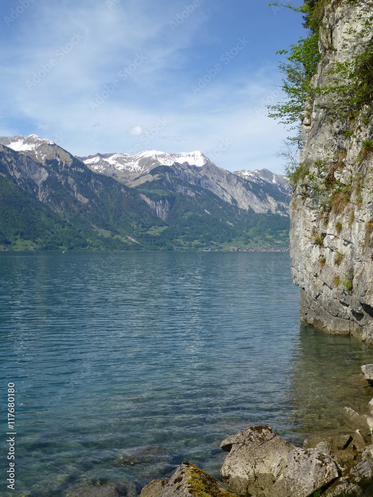 Φωτογραφία Rock face on the shores of Brienzersee lake, Switzerland, with snow-capped Rotho