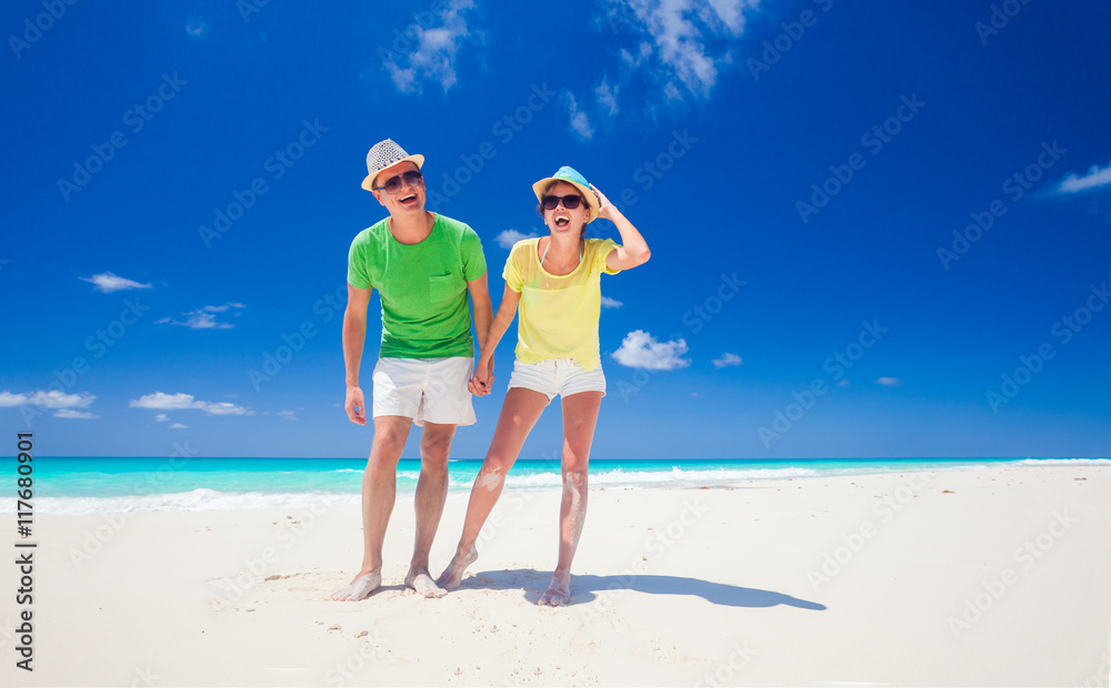 couple in bright clothes having fun at tropical beach couple in bright clothes having fun at tropical beach
