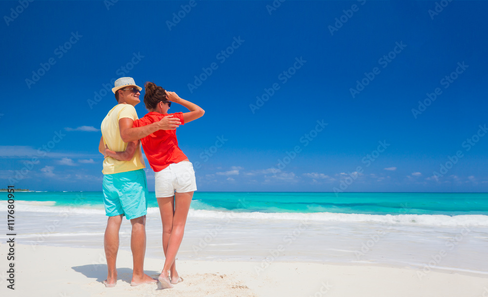 Romantic couple in bright clothes enjoying sunny day at tropical beach Romantic couple in bright clothes enjoying sunny day at tropical beach