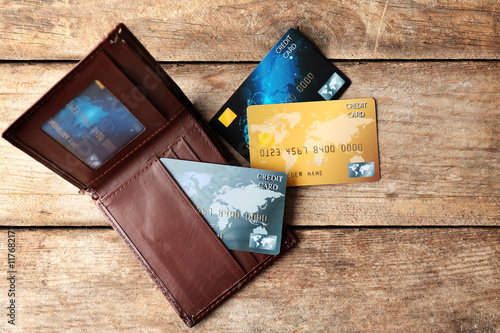 Credit cards in leather wallet on wooden background photo