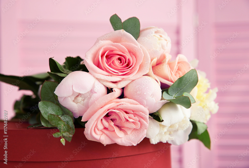 Beautiful bouquet of flowers on red gift box Beautiful bouquet of flowers on red gift box