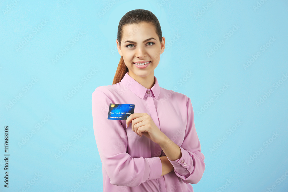 Beautiful businesswoman with credit card on blue background Beautiful businesswoman with credit card on blue background