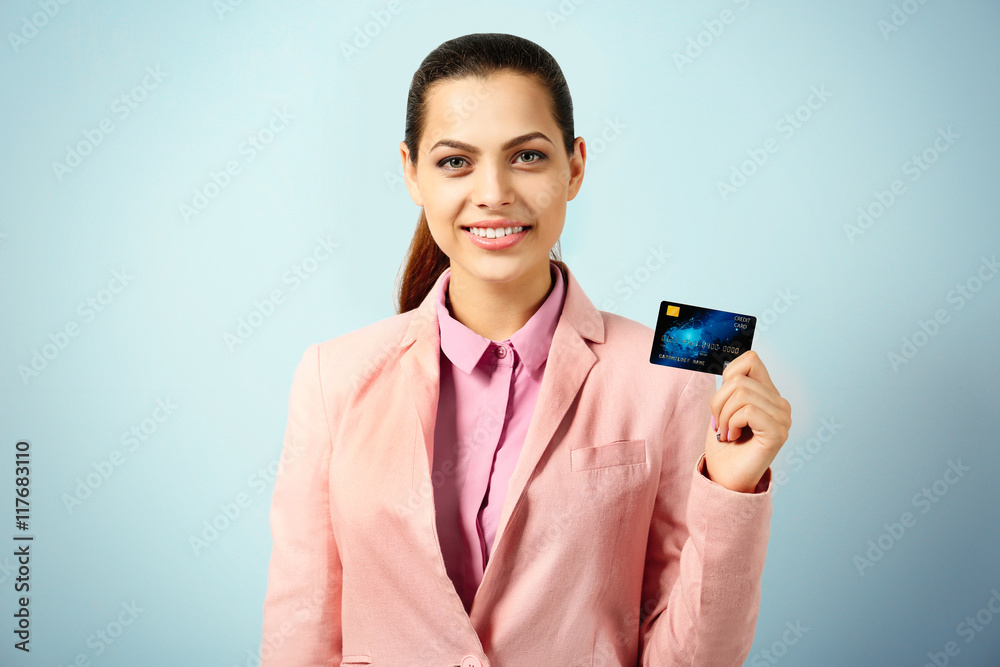 Beautiful businesswoman with credit card on blue background Beautiful businesswoman with credit card on blue background