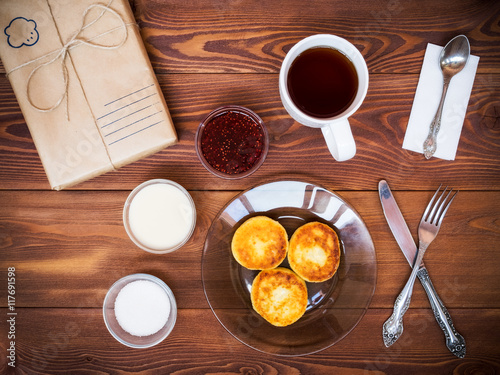 Tea set for breakfast on the table. Wrapped gift with place for customer text. View from above