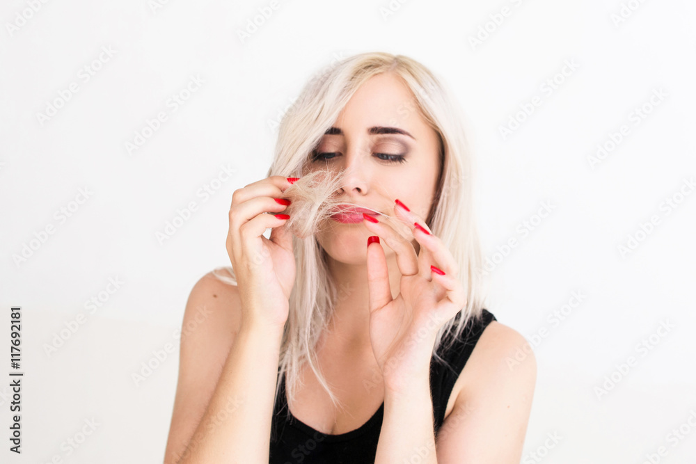 Blonde woman looking at her hair tips. Bad condition of dyed hair, awful hairdresser work Blonde woman looking at her hair tips. Bad condition of dyed hair, awful hairdresser work