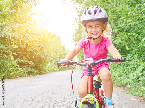 Happy child riding a bike in outdoor.