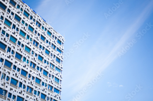 Modern glass and metal facade high-rise business building and blue skies