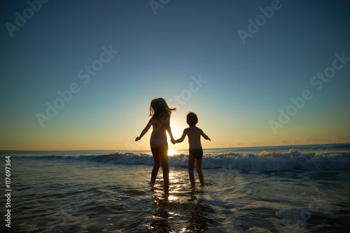 boy and girl on the sea at sunset © photoniko
