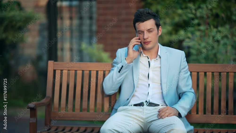 Young businessman talking on the phone in the park Young businessman talking on the phone in the park