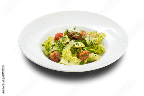 vegetable salad with mozzarella tomatoes on a white plate and a white background