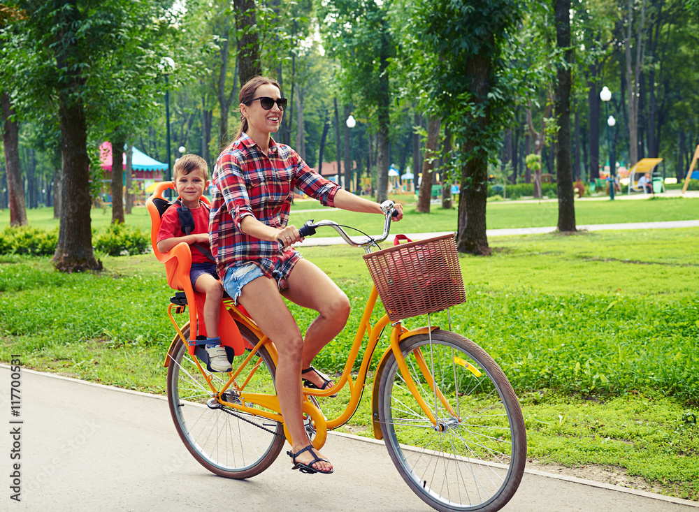 Obraz premium Young active mother and son having fun during a bicycle ride