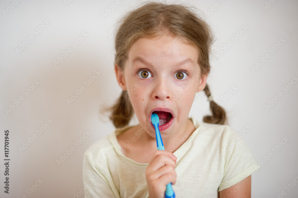 Cute girlie with pigtails diligently brushing his teeth.