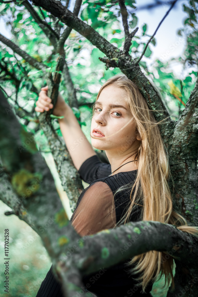 Girl in jeans outdoors. The girl near a tree. Girl in jeans outdoors. The girl near a tree.