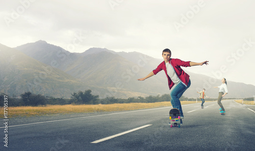 Teenagers ride skateboard . Mixed media