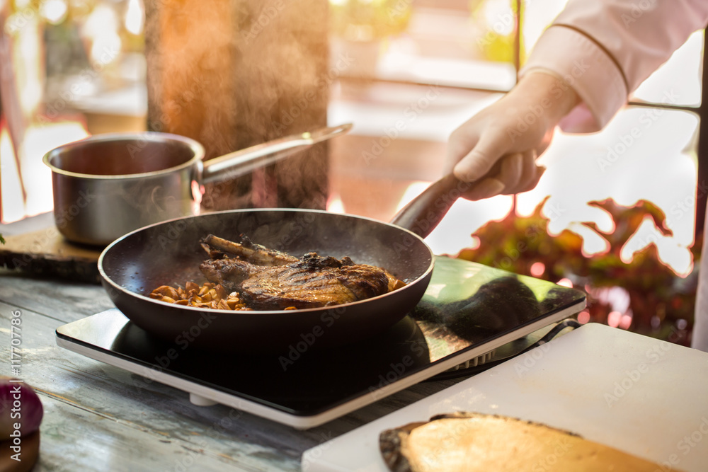 Meat is frying with mushrooms. Hand in glove touches pan. Grilled pork and chanterelles. How to cook savoury lunch. Meat is frying with mushrooms. Hand in glove touches pan. Grilled pork and chanterelles. How to cook savoury lunch.