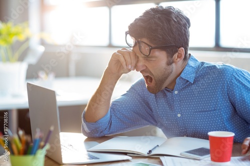Male business executive yawning photo