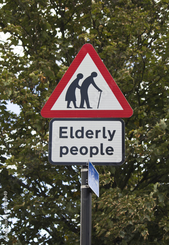 Elderly people road sign in London, with a tree in the background