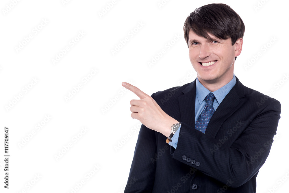 Smiling businessman pointing out something Smiling businessman pointing out something