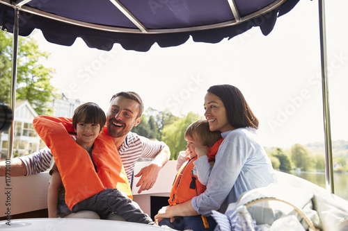Family Enjoying Day Out In Boat On River Together