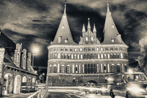 Medieval Holstentor gate with city night traffic in hanseatic ci