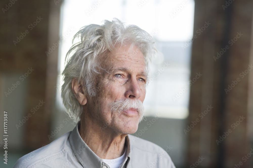 Thoughtful senior man looking away in gym Thoughtful senior man looking away in gym