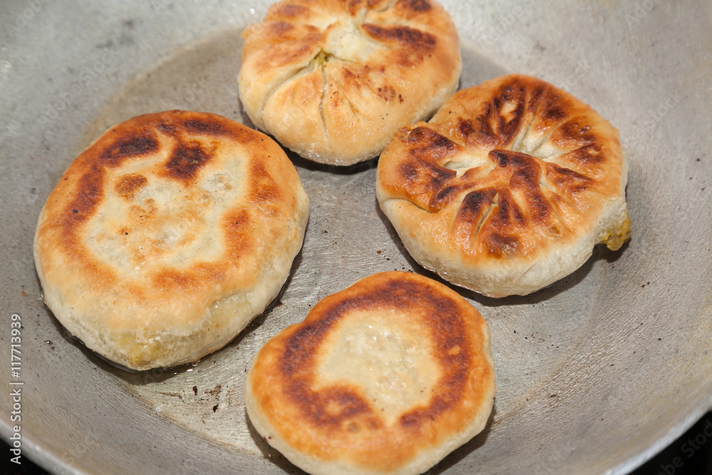 four pieces of fried bhatura in pan with selective focus four pieces of fried bhatura in pan with selective focus