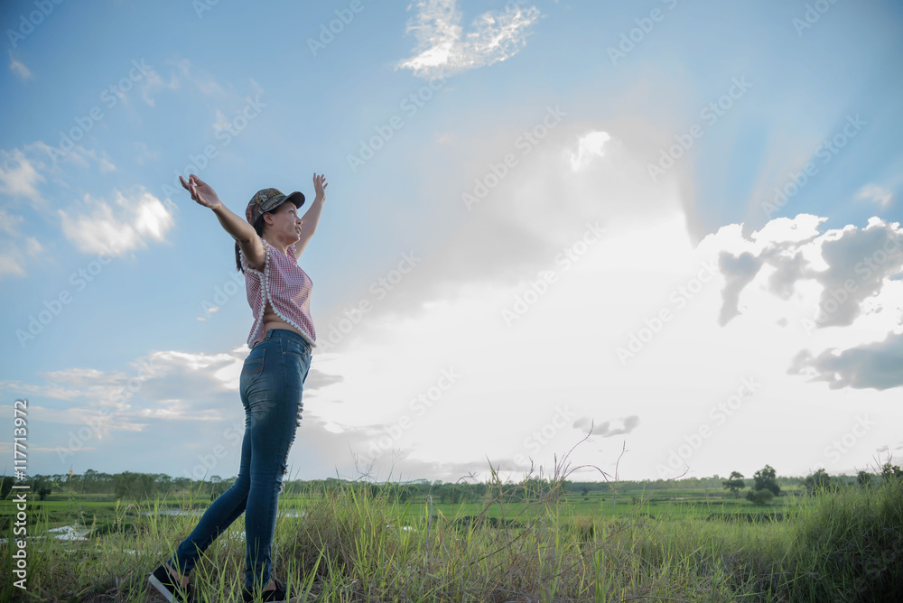 Fototapeta premium A woman in a field in the sky