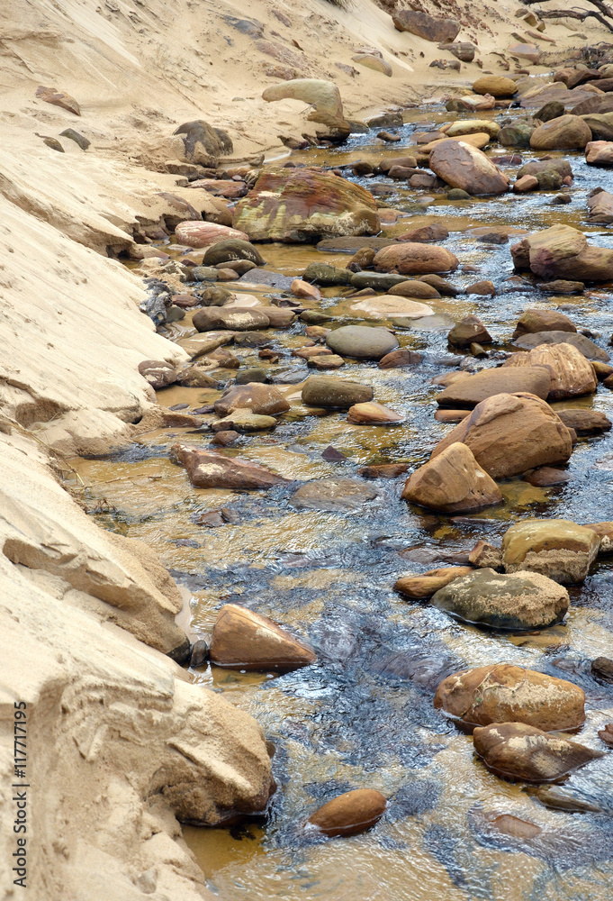 Sandstone boulders in a sandy freshwater creek Sandstone boulders in a sandy freshwater creek