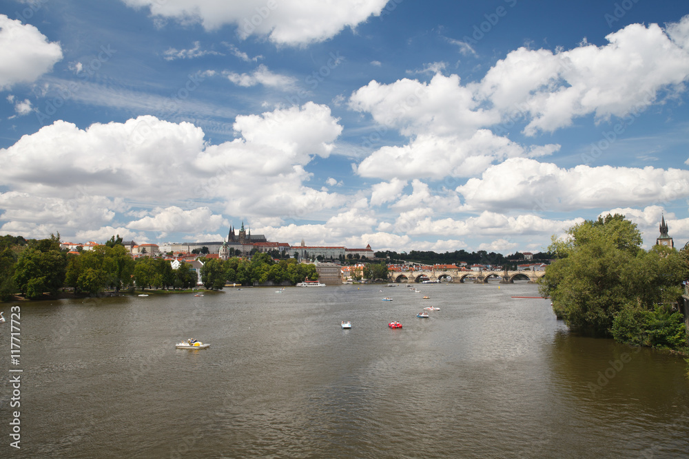 Naklejka premium Rest on the Vltava river in the summer. View of Prague Castle and Charles Bridge