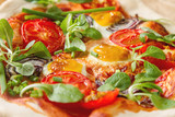 Home Italian pizza with tomato and quail eggs salad on a baking