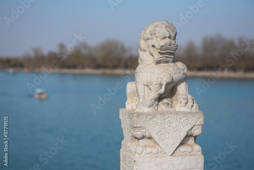 Stone lion statue on Seventeen Hole Bridge in Summer Palace