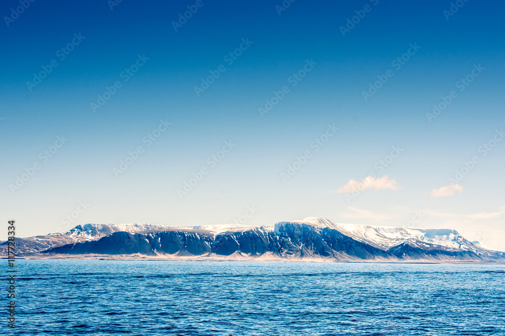 Snow on mountains in the blue ocean