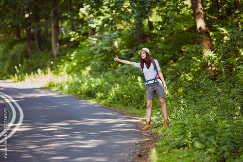 Worried young woman hitch hiking