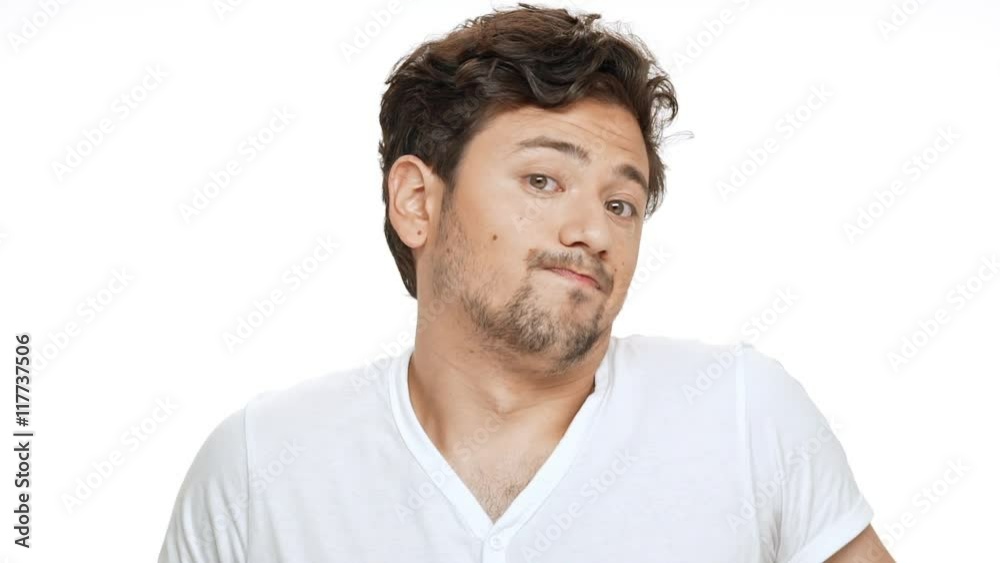 Young handsome man shruging, looking at camera over white background. Slow motion. Young handsome man shruging, looking at camera over white background. Slow motion.