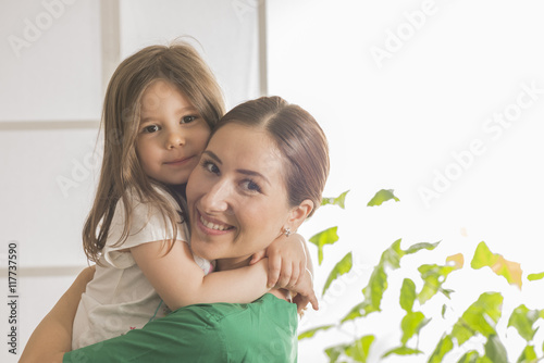 Beautiful little girl hugging woman doctor. Doctor and a smiling girl patient