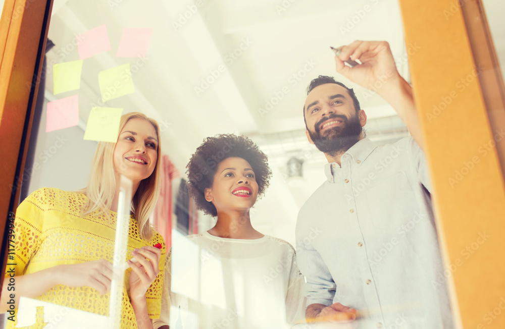 Fototapeta premium happy creative team writing on stickers at office